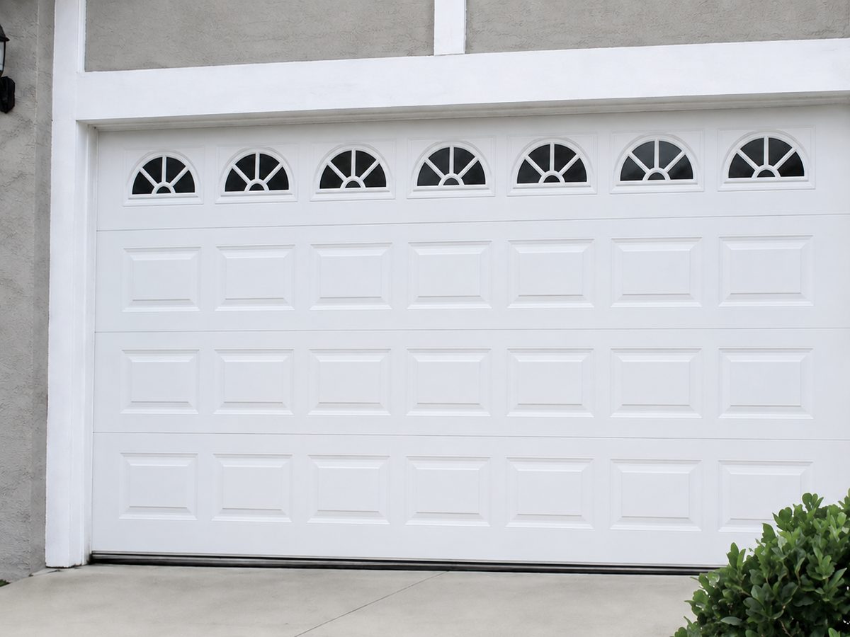 New white garage door with arched windows after replacement