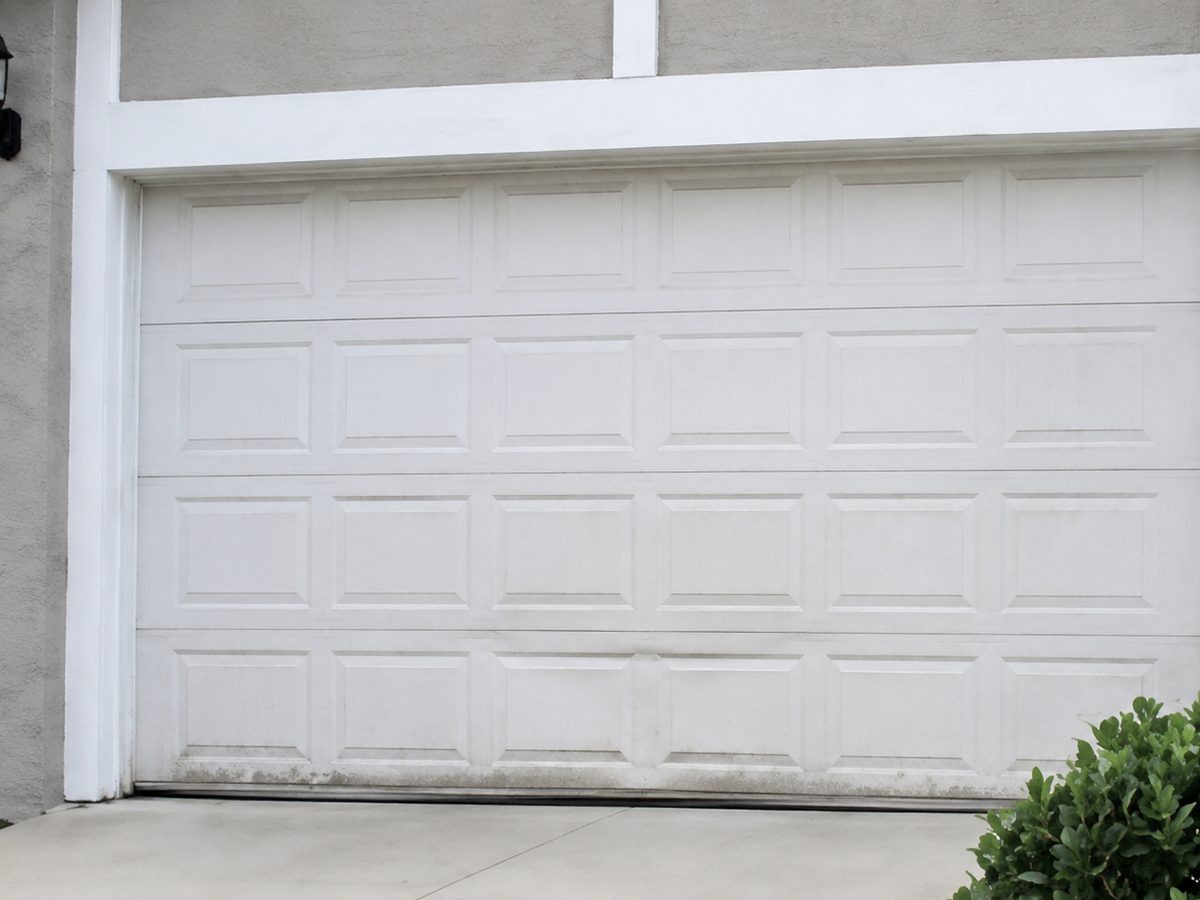 Worn raised-panel garage door before replacement