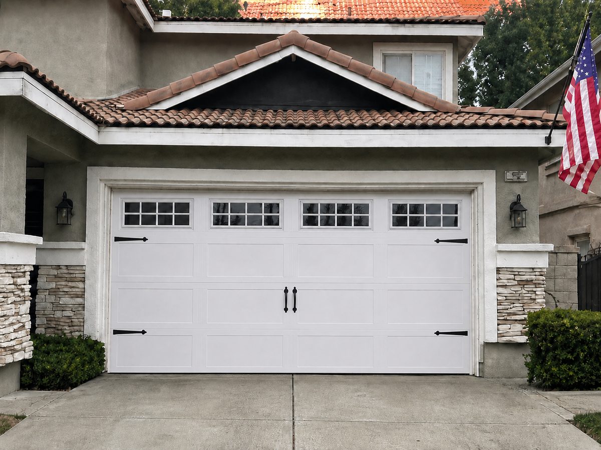 New carriage-style garage door with windows and decorative hardware