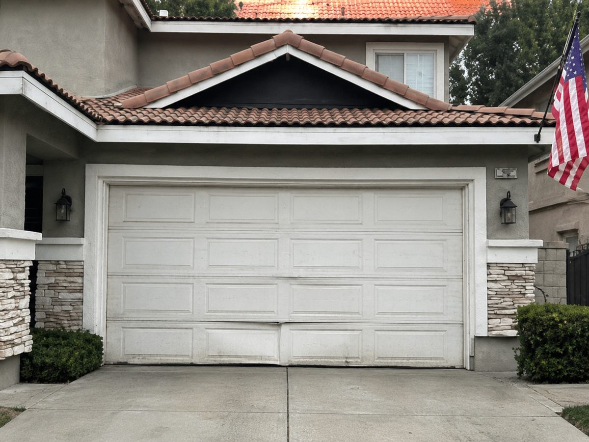 Dented garage door panel before replacement