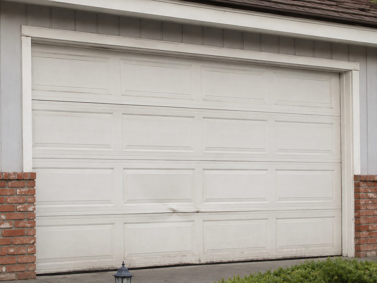 Dented and stained garage door before replacement